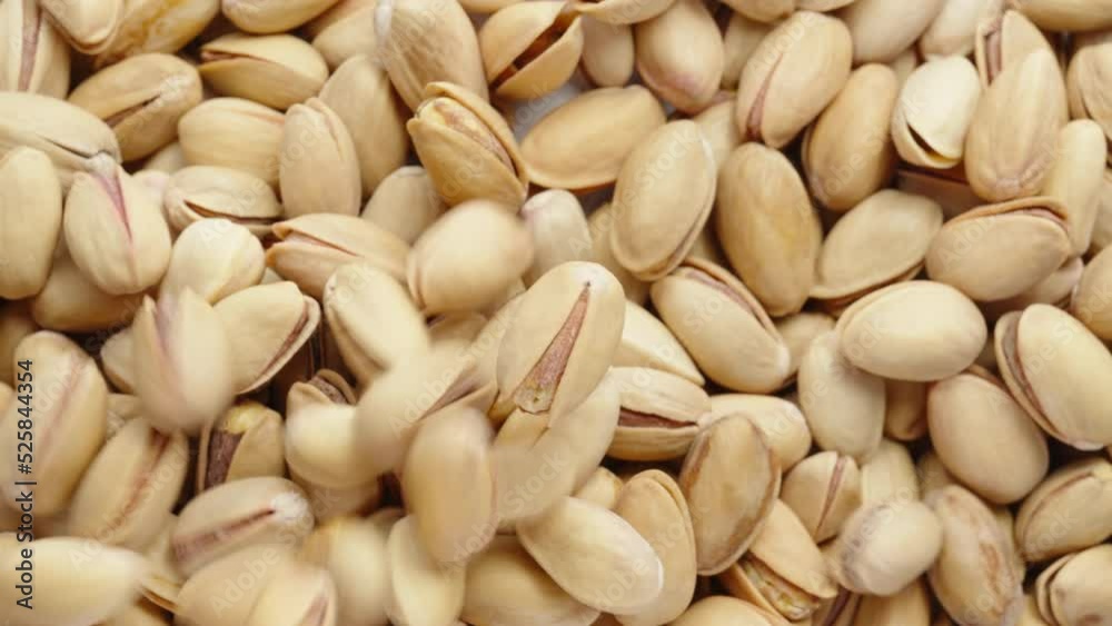 One salted pistachio rotates, they pour on the table. Close-up. One salted pistachio rotates, they pour on the table. Close-up.