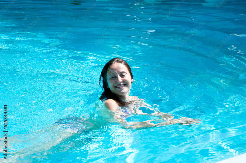 girl smile swimming in summer pool water on vacation
