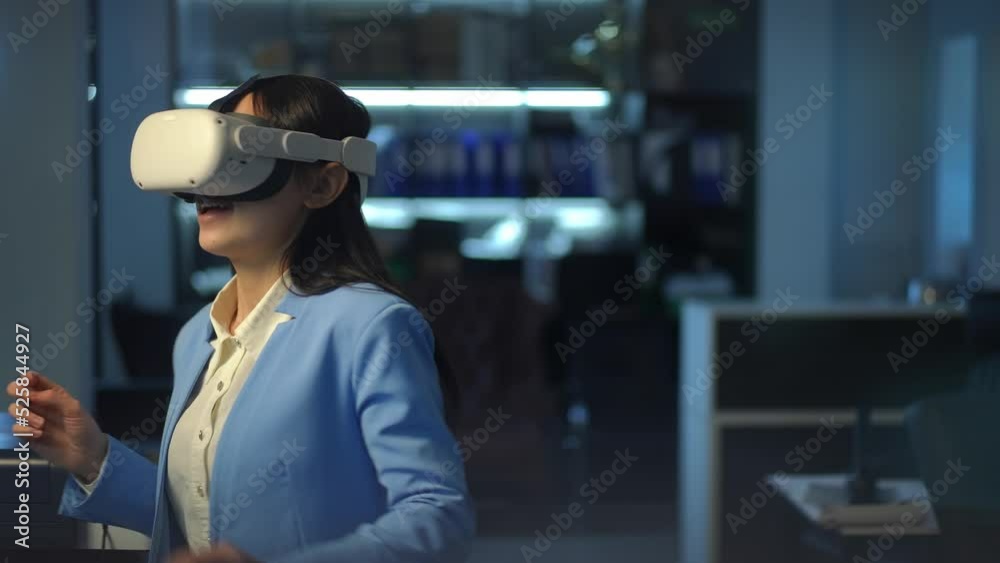 Relaxed cheerful Asian young woman in VR headset dancing in office in the evening. Portrait of joyful slim female employee enjoying hobby after work. Life balance and lifestyle concept Relaxed cheerful Asian young woman in VR headset dancing in office in the evening. Portrait of joyful slim female employee enjoying hobby after work. Life balance and lifestyle concept