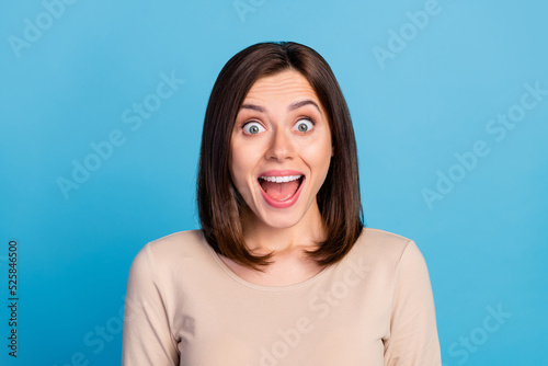 Photo of astonished young girl toothy smile open mouth isolated on blue color background