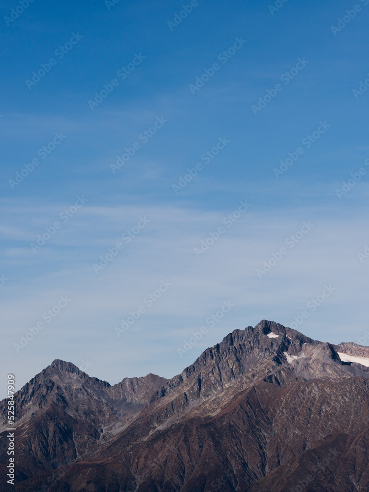 A harsh view of bare mountain peaks against a clear sky. Mountain landscape, freedom and beauty of nature