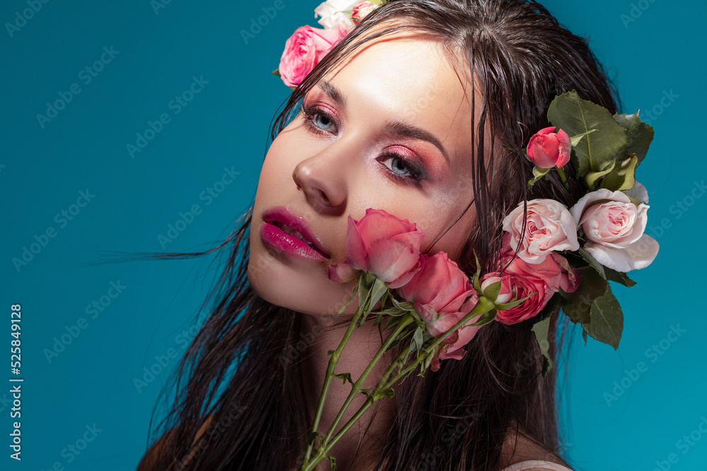 Luxury portrait of a beautiful young woman with roses and fresh bright makeup, nautical style, blue background