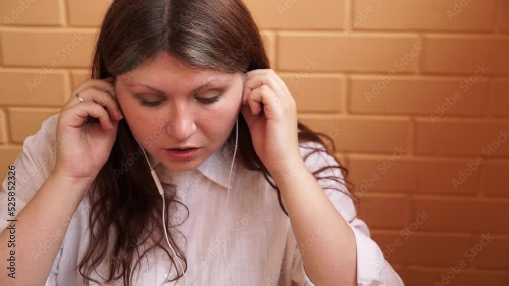 Girl puts on and takes off white headphones Girl puts on and takes off white headphones
