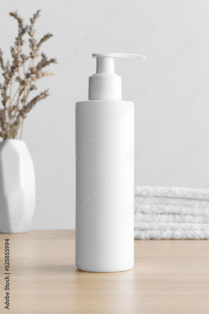 White cosmetic shampoo dispenser bottle mockup with a lavender and towels on the wooden table. White cosmetic shampoo dispenser bottle mockup with a lavender and towels on the wooden table.
