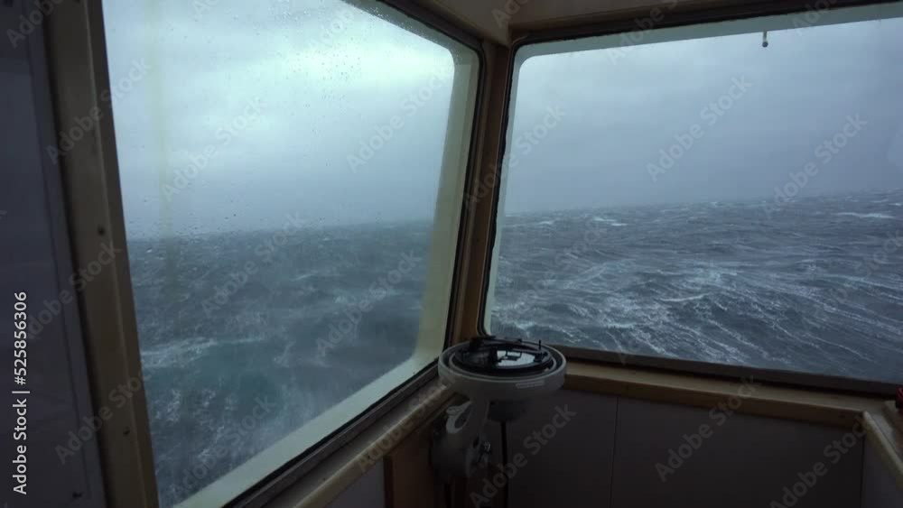 Ship in storm. Strong pitching. View from bridge wing. High waves hit vessel. White foam on water. Compass Ship in storm. Strong pitching. View from bridge wing. High waves hit vessel. White foam on water. Compass