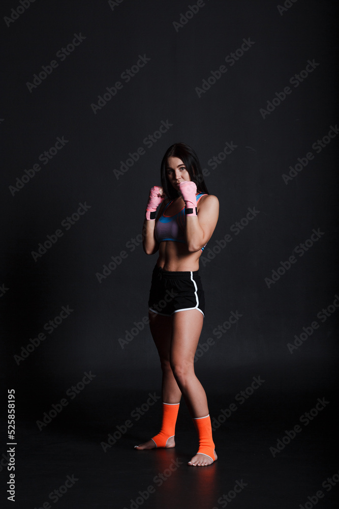 Sportsman muay thai woman boxer posing in training studio