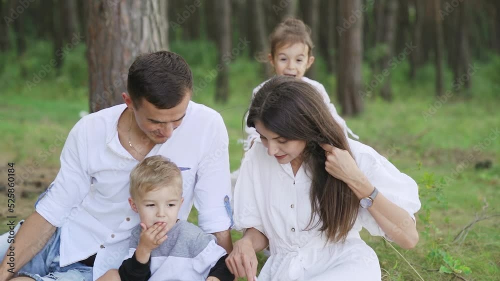Daughter hugs dad on family picnic. Loving family having picnic in pine forest Daughter hugs dad on family picnic. Loving family having picnic in pine forest