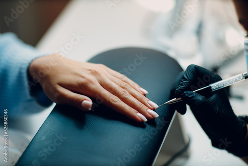 Manicure process female hands finger nails polish.