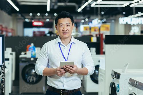 Fotografie Happy Asian manager shop manager salesman smiling and looking at camera, man sel