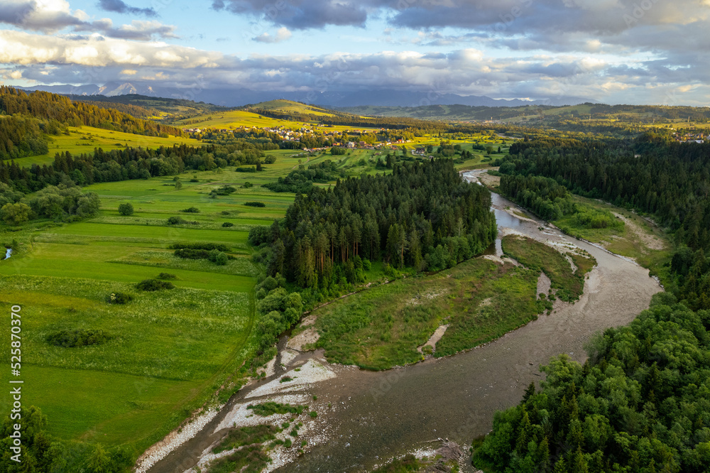 Obraz premium Bialka River in Podhale region, High tatras mountains in Poland at sunset. Drone View