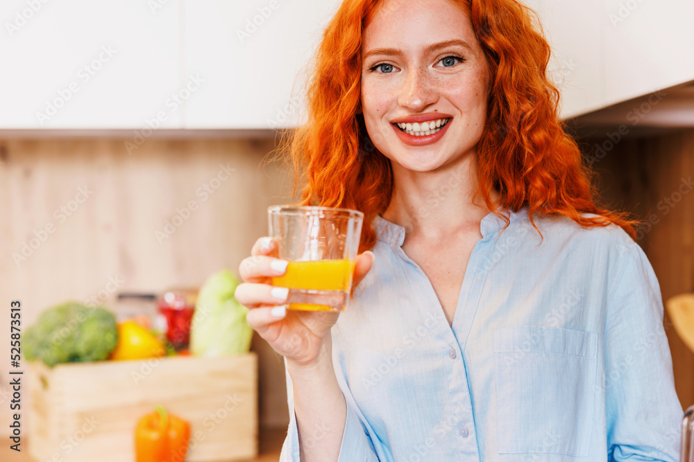 Young woman in kitchen. Beautiful woman in modern kitchen drinking orange juice. Young woman in kitchen. Beautiful woman in modern kitchen drinking orange juice.