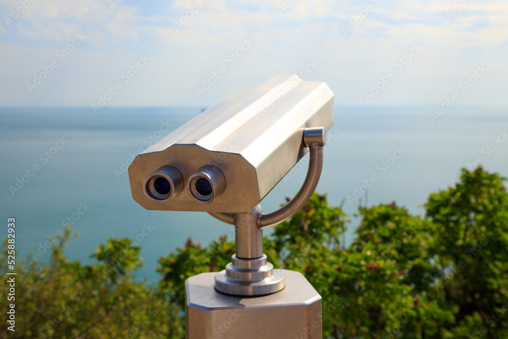 Coin Operated Binocular viewer or touristic telescope, trees and sea, panoramic view. Closeup. Coin Operated Binocular viewer or touristic telescope, trees and sea, panoramic view. Closeup.