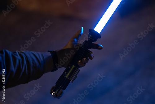 Φωτογραφία Man holding Lightsaber with blue emitted blade