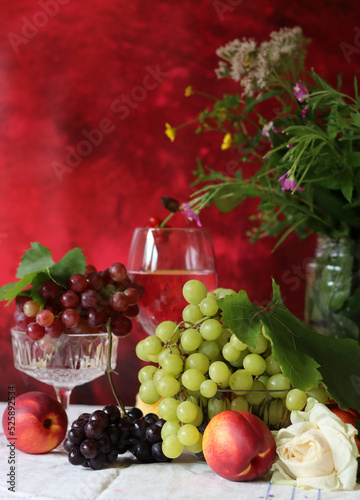 Wine and fruit on a table. Beautiful composition of juicy berries  grapes and rose wine. Harvest celebration. Textured background with copy space. 