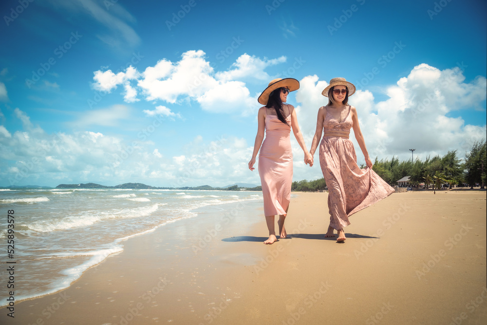 Portrait of two Happy traveller woman wearing straw in dress enjoys her during summer tropical beach vacation. Holiday and summer travel concept Portrait of two Happy traveller woman wearing straw in dress enjoys her during summer tropical beach vacation. Holiday and summer travel concept