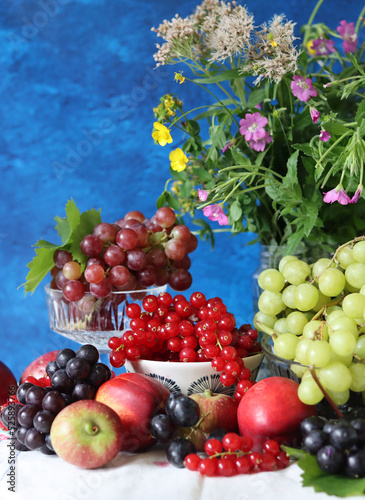 Fototapeta Naklejka Na Ścianę i Meble -  Colorful still life with seasonal berries on a table. Red currant, green grapes, nectarines and apples close up photo. Nutrition concept. 