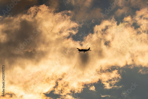 the silhouette of a propeller airplane on the evening sky