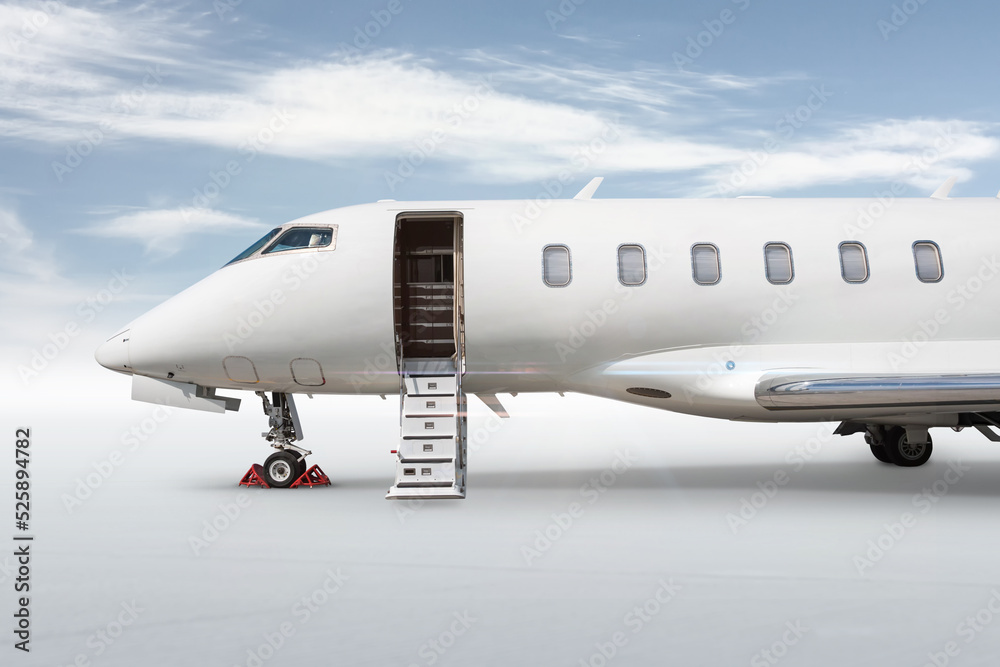Close-up of the front of the modern white business jet with an opened gangway door isolated on bright background with sky - obrazy, fototapety, plakaty 