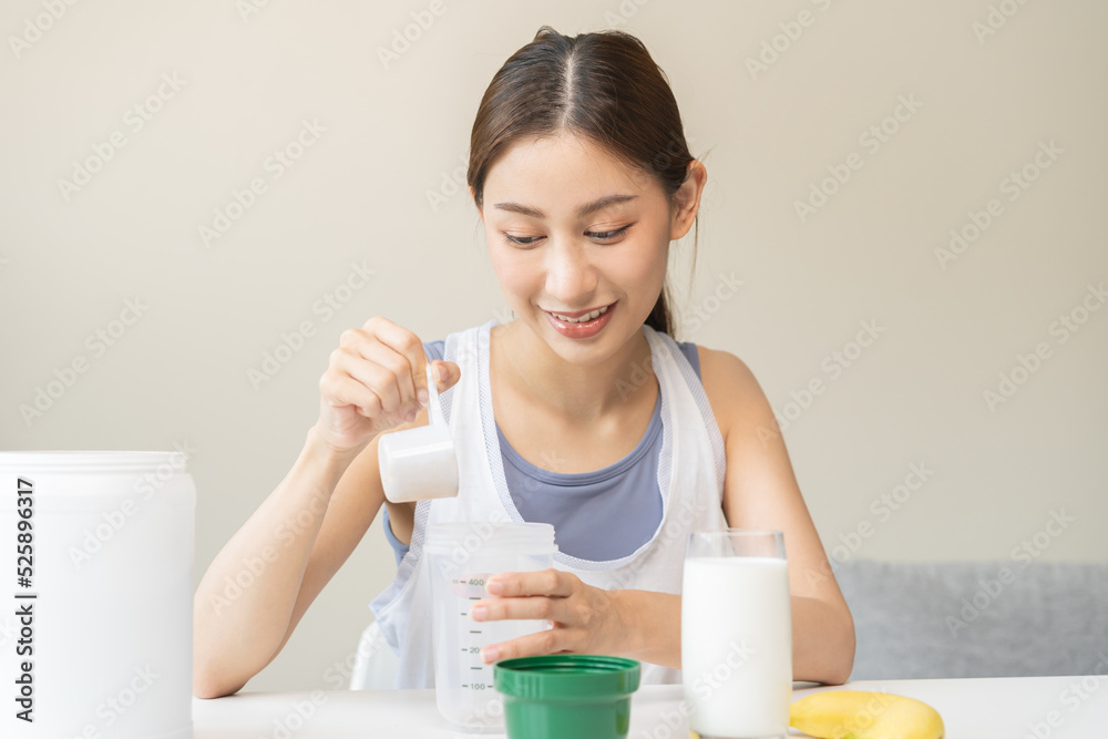 Diet meal replacement for weight loss, smile asian young woman, girl in sportswear, hand in holding scoop making protein shake, drink supplement for muscle after workout at home. Healthy body care. Diet meal replacement for weight loss, smile asian young woman, girl in sportswear, hand in holding scoop making protein shake, drink supplement for muscle after workout at home. Healthy body care.