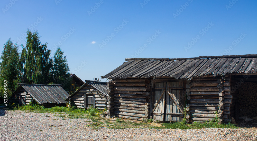 The ancient Shchurovskoye settlement in Suzdal in Russia with medieval wooden buildings among the bright green foliage of trees and blue clear sky on a sunny summer day The ancient Shchurovskoye settlement in Suzdal in Russia with medieval wooden buildings among the bright green foliage of trees and blue clear sky on a sunny summer day