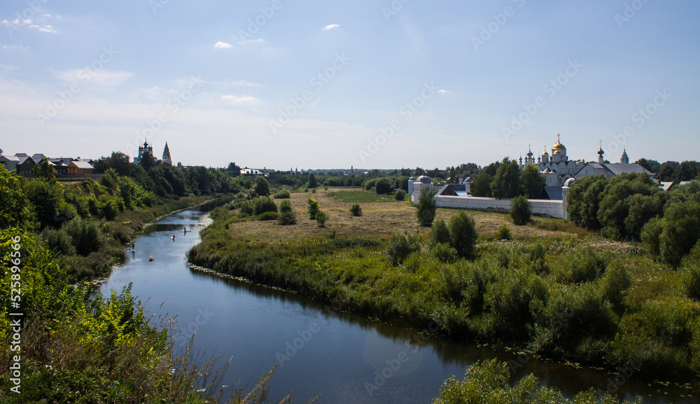 Tourists are rafting on the winding Kamenka river in Suzdal Russia among meadows with grass on a sunny summer bright day and a space for copying