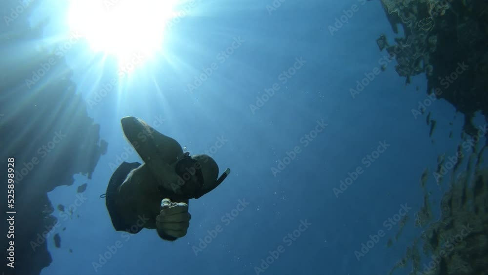 underwater scene of a man swimming and floating in a blue crystal clear watter beach. Concept of sport, holiday and travel.
