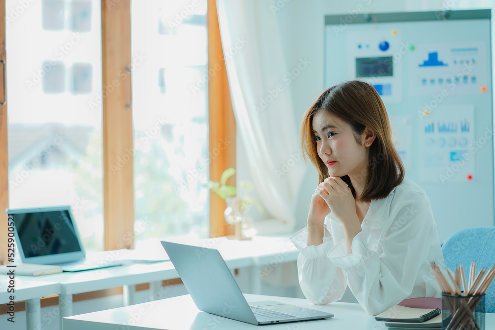 Attractive young Asian beauty accountant in office using laptop and financial documents on office desk. Attractive young Asian beauty accountant in office using laptop and financial documents on office desk.