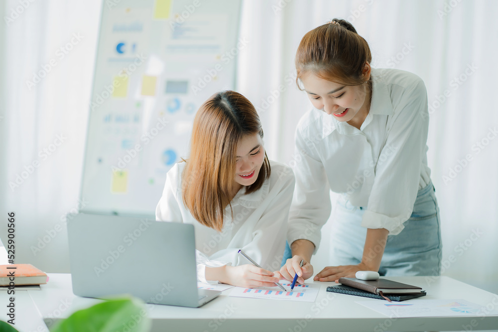Two Asian women talk, discuss, work on the new start-up project idea. Analyze financial graphs, marketing plans and office investments. Two Asian women talk, discuss, work on the new start-up project idea. Analyze financial graphs, marketing plans and office investments.