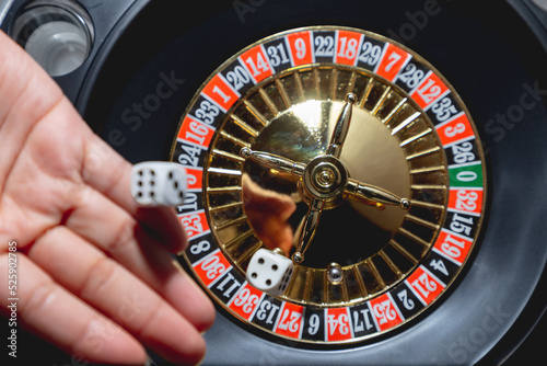 Mano femenina lanzando dados y girando ruleta, concepto de casino juegos de azar photo