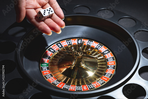 Photography Mano femenina lanzando dados y girando ruleta, concepto de casino juegos de azar