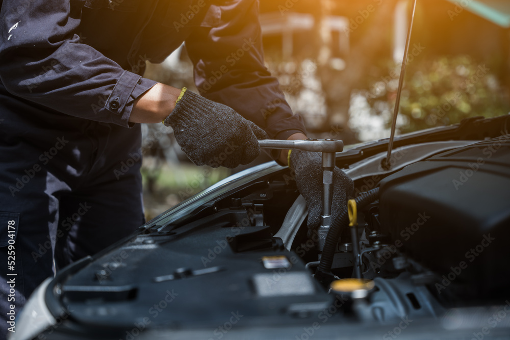 Male mechanic is checking the car maintenance lists for maintenance and fixing the car. Male mechanic is checking the car maintenance lists for maintenance and fixing the car.