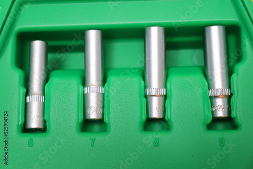 metal tools, screwdrivers and bits for repair in a green box © Diana Kozii