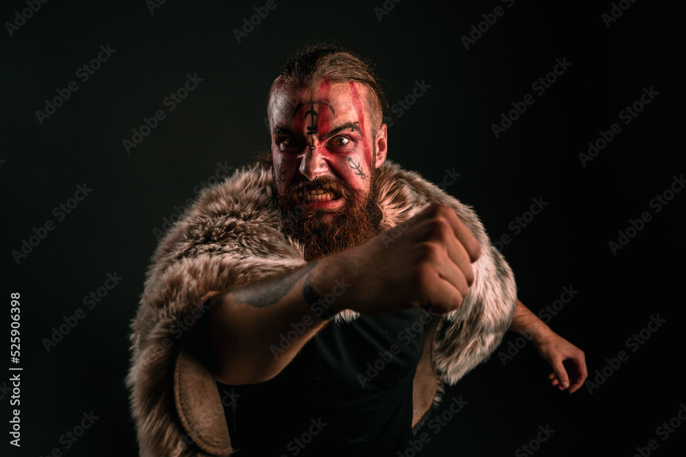 Angry Viking warrior with war paint, attacking his foe in anger and rage