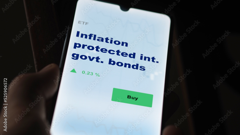An investor's analyzing the i-bond on screen. A phone shows the ETF's prices inflation protected int. government bonds An investor's analyzing the i-bond on screen. A phone shows the ETF's prices inflation protected int. government bonds