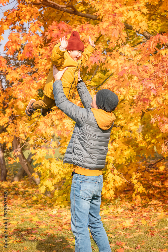 Father lifting daughter up to the sky in an autumn park. Happy father and child daughter on autumn walk. Father lifting daughter up to the sky in an autumn park. Happy father and child daughter on autumn walk.