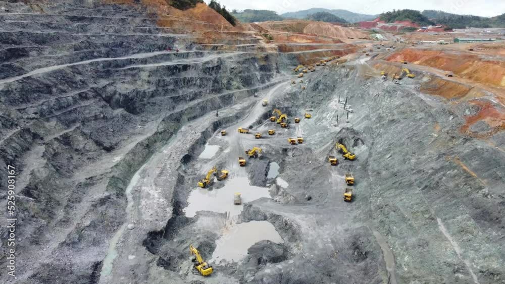 Excavator working on earth moving at open pit mining on amazing sunset ...
