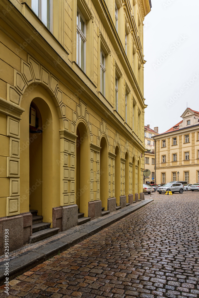 Obraz premium A yellow building on the edge of a cobbled street.