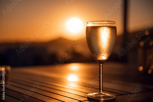 Fototapeta Naklejka Na Ścianę i Meble -  Traditional house white wine served in tavern, traditional greece drink, mazing sunset as background