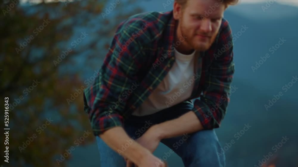 Closeup ginger traveler camping on dusk. Young guy enjoy campfire on nature. Closeup ginger traveler camping on dusk. Young guy enjoy campfire on nature.