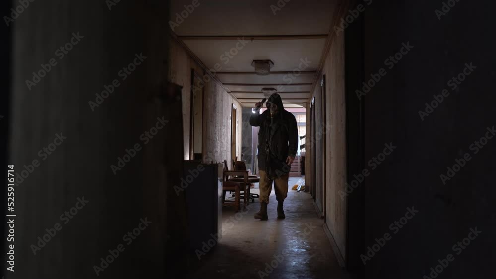 male researcher in a gas mask with a flashlight inside the corridor of an old ruined room, finds canned food in an old refrigerator. The concept of post-apocalyptic world. Looking for food male researcher in a gas mask with a flashlight inside the corridor of an old ruined room, finds canned food in an old refrigerator. The concept of post-apocalyptic world. Looking for food