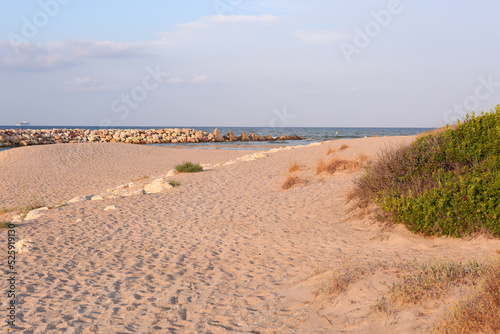 natural stony beach seaside landscape in Spain with sand spit close up photo