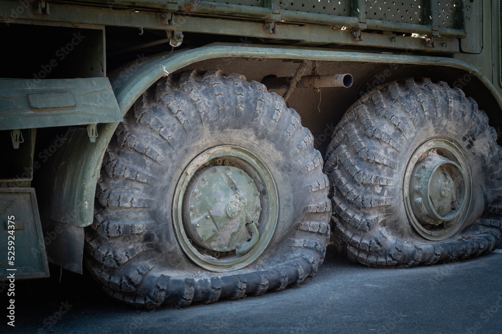 Flat tires on old military equipment. Fragment of a broken army car Flat tires on old military equipment. Fragment of a broken army car
