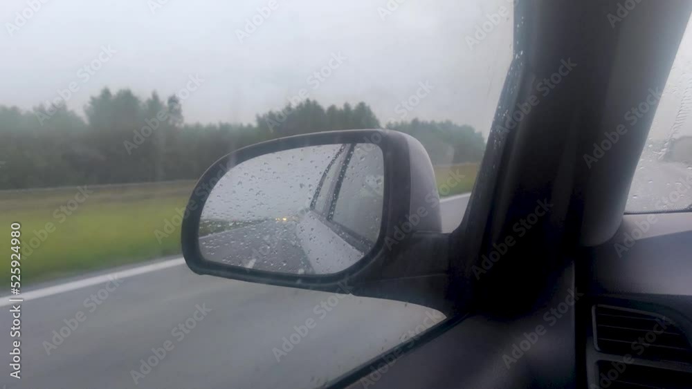Car wing mirror view during a heavy rainy drive. Car wing mirror view during a heavy rainy drive.