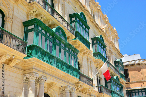 Traditional green balconies, Maltese architecture and national flag in Valletta, Malta