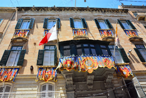 Colorful decoration, banners on building facade in old city of Valletta, Malta