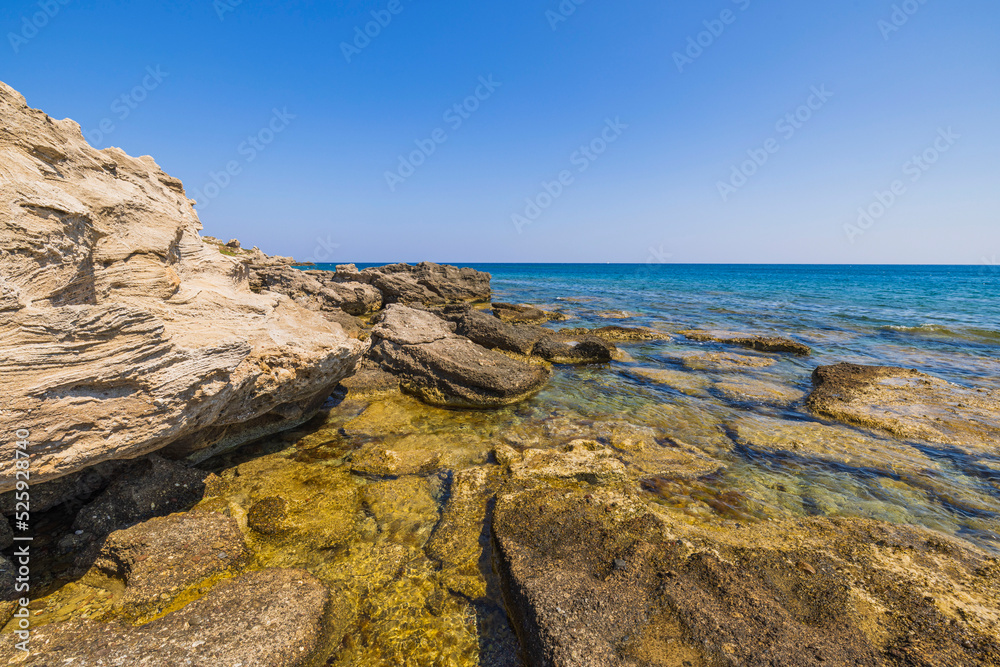Beautiful view of rocky coastline. Blue sea water and sky merge at horizon. Beautiful view of rocky coastline. Blue sea water and sky merge at horizon.
