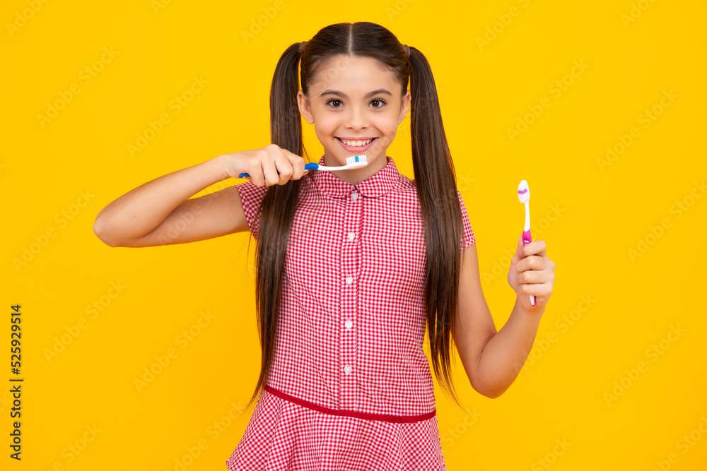 Teenager girl brushing her teeth over isolated yellow background. Daily hygiene teen child hold toothbrush, morning routine. Dental health oral care. Happy teenager, positive and smiling. Teenager girl brushing her teeth over isolated yellow background. Daily hygiene teen child hold toothbrush, morning routine. Dental health oral care. Happy teenager, positive and smiling.
