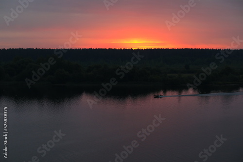 Dawn over the river with a passing boat on the water