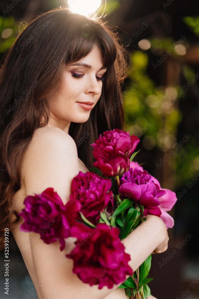 an beautiful woman with long hair and bare shoulders and a bouquet of peonies