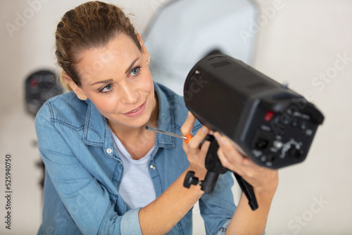 female photographer setting up lighting equipment